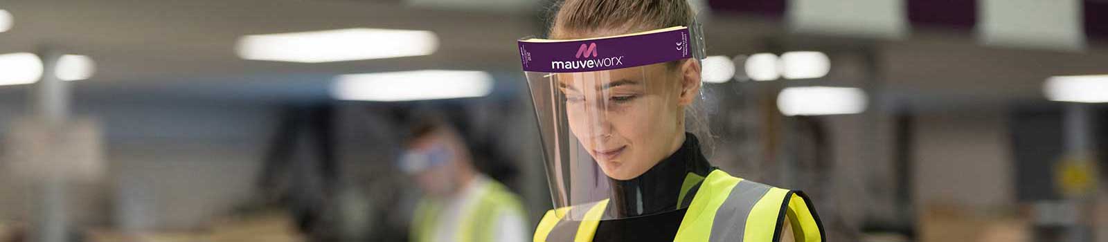 Key worker using custom branded face shield in factory wearing high vis jacket